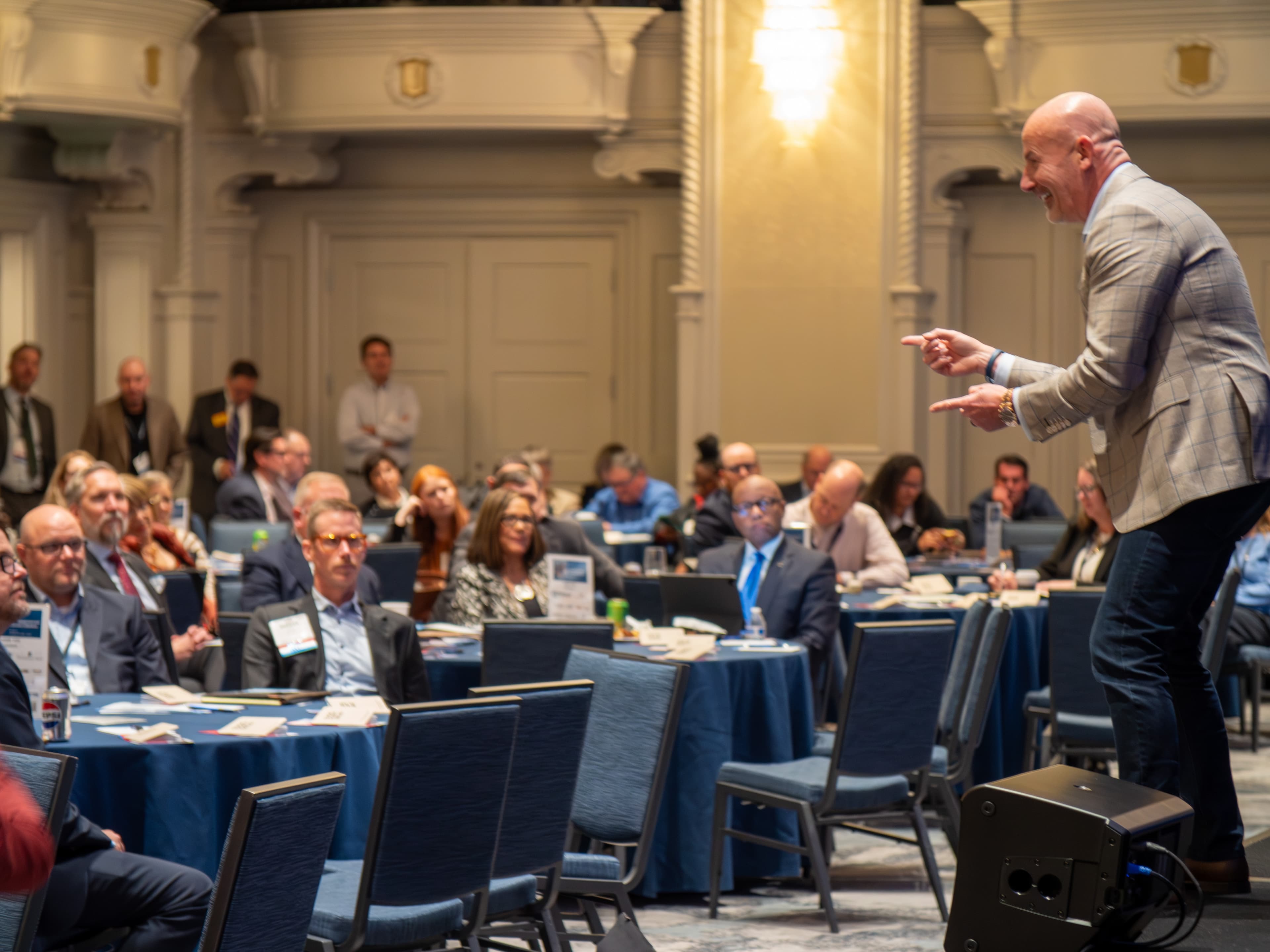 Steve Lowisz speaking to a packed ballroom audience